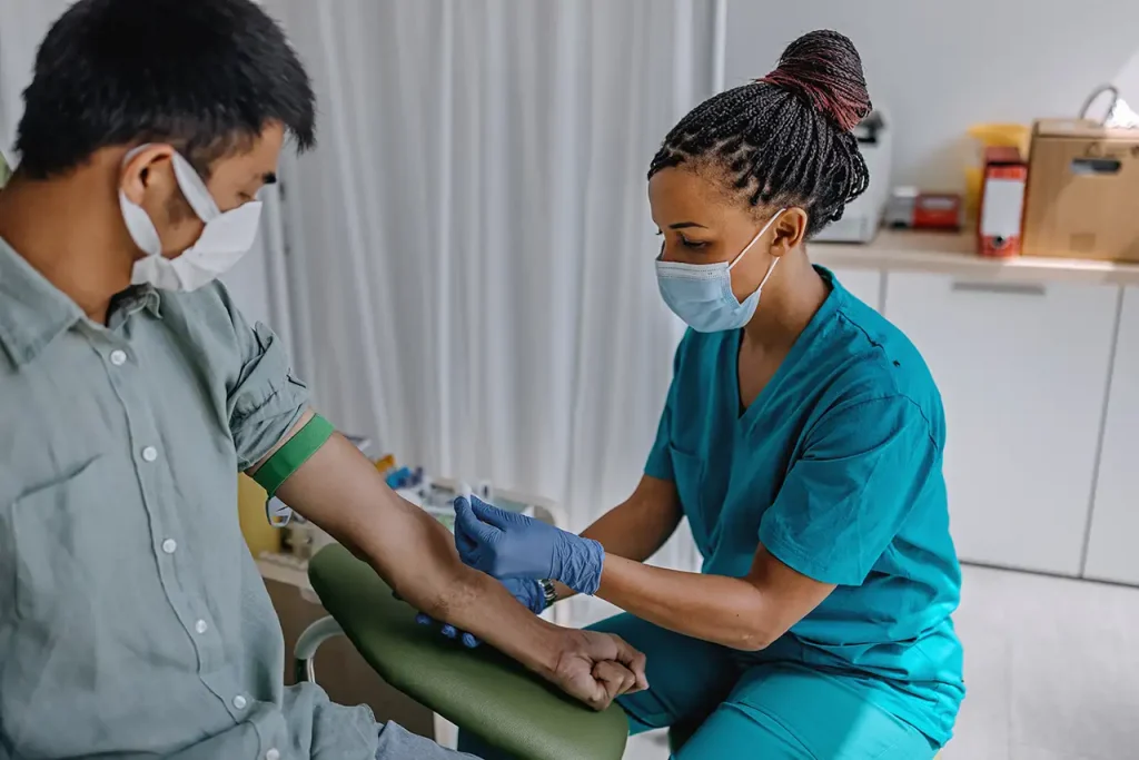 healthcare worker preparing patient for blood drawing