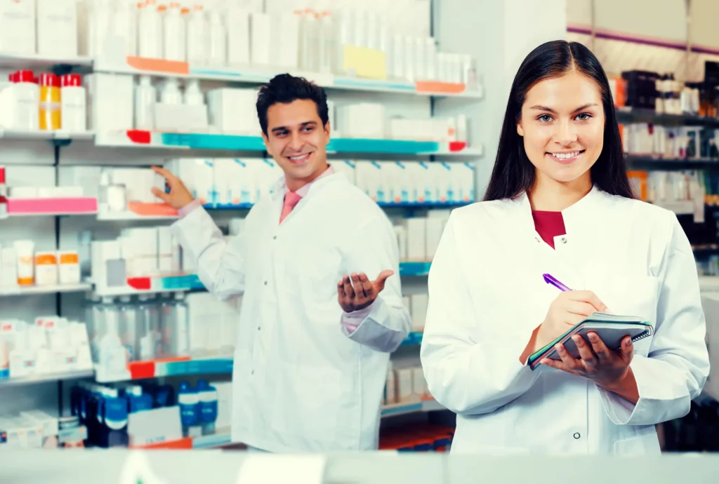 male and female pharmacy professional smiling at camera